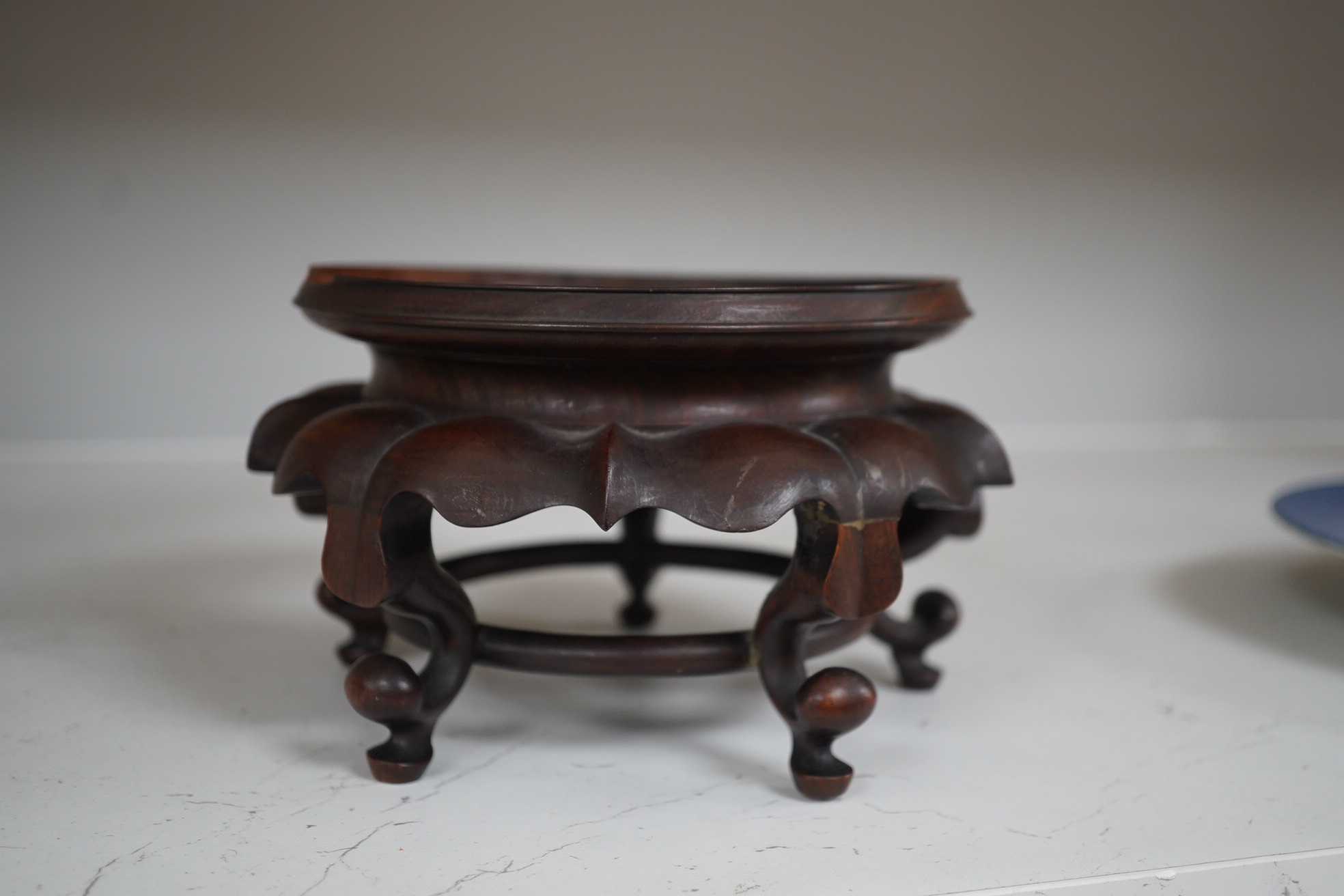 A Chinese cloisonné enamel ‘dragon’ bowl, Qianlong mark but early 20th century, on hardwood stand, 20cm diameter. Condition - poor to fair